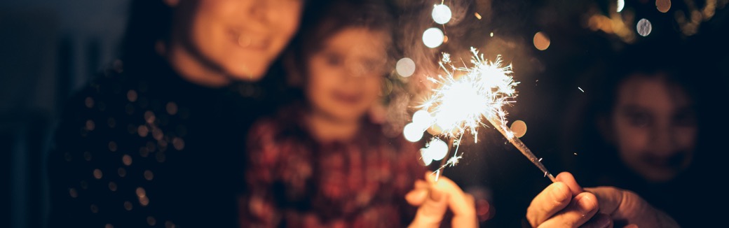 family looking at sparkler at night