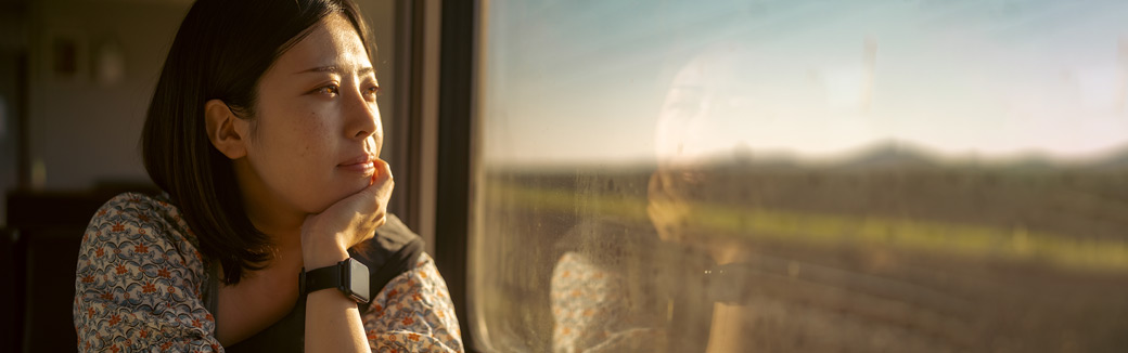 young woman looking wistfully out a window